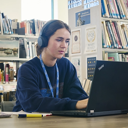 A student sketching at a desk