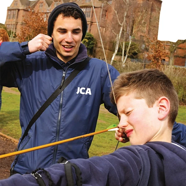 instructor helping child with archery