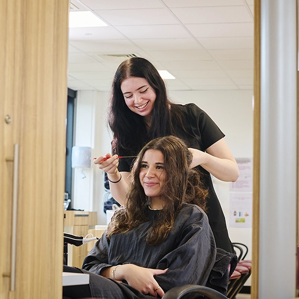 young person styling hair of client
