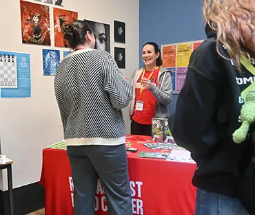 Student talking to person on Race Against Blood Cancer stand