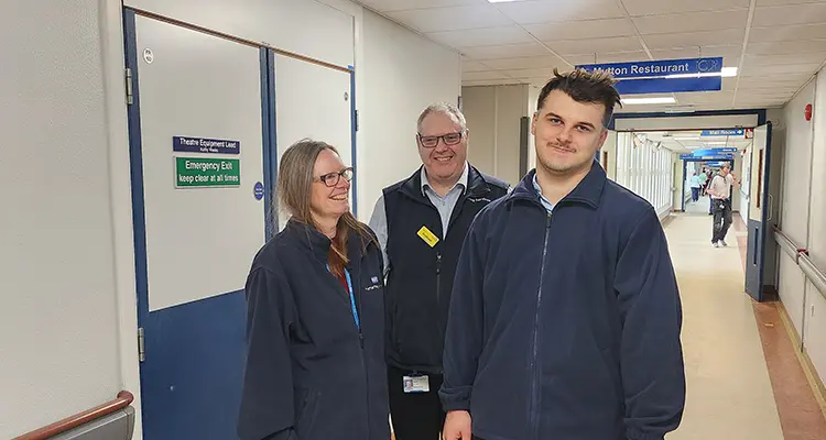 Two students and porter in hospital corridor 