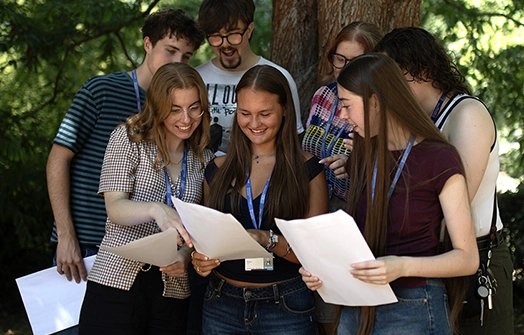 young students sitting at a bench outside