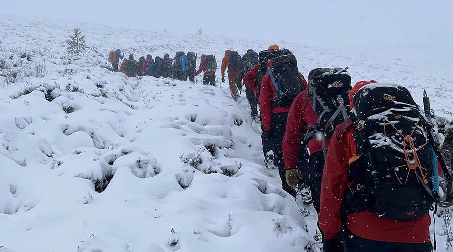 Group of students walking through snowy mountains